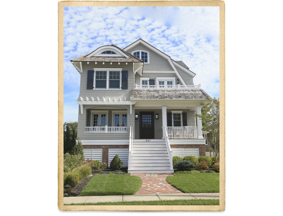 Tan Two Story House With Cedar Shakes And White Trim And Picket Fence