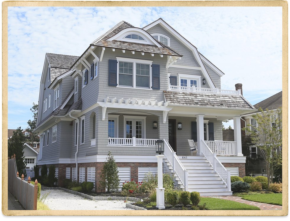 Tan Two Story House With Cedar Shakes And White Trim And Picket Fence